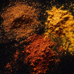 Assorted colorful dry powdered spices on black background